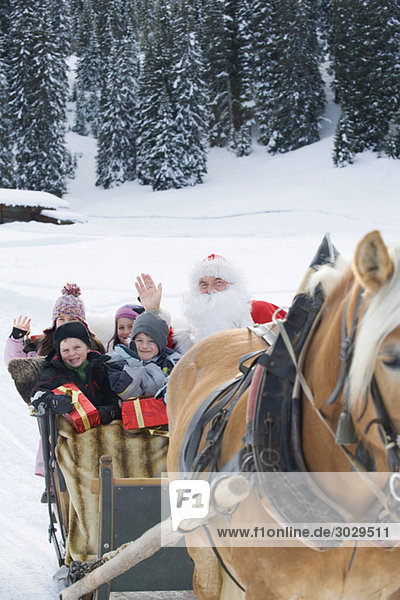 Italy  South Tyrol  Seiseralm  Santa Claus and children taking a sleigh ride
