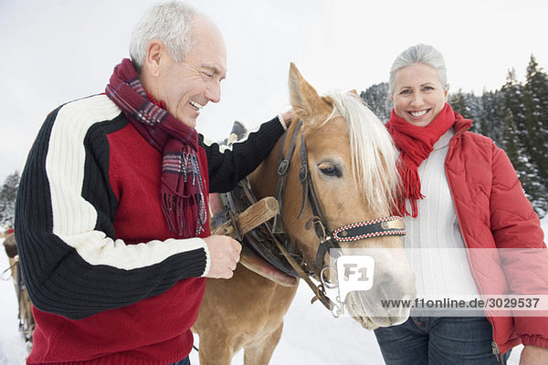 Italien  Südtirol  Seiseralm  Seniorenpaar zu Pferd  lächelnd  Portrait  Nahaufnahme
