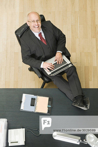 Germany  Munich  Businessman working at laptop  elevated view