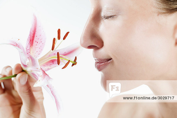 Junge Frau mit Orchideenblüte  Augen geschlossen  Portrait