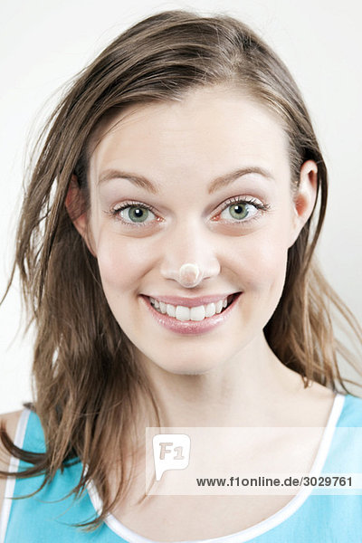 Young woman with cream on her nose  smiling  portrait