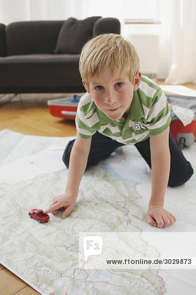 Junge (8-9) kniend auf Karte  Portrait