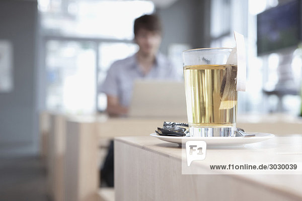 Junger Mann im Cafe mit Laptop,  Tee im Vordergrund