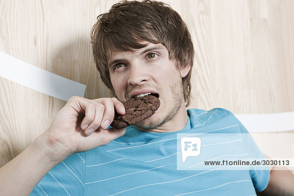 Mann,  der einen Schokoladenkeks isst,  Porträt