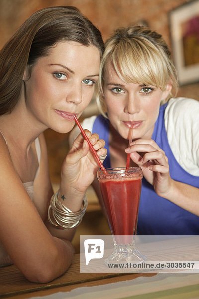 Zwei Frauen  die Bloody Mary in einem Café trinken.
