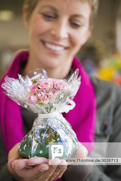 Frau hält einen Blumenstrauß und lächelt