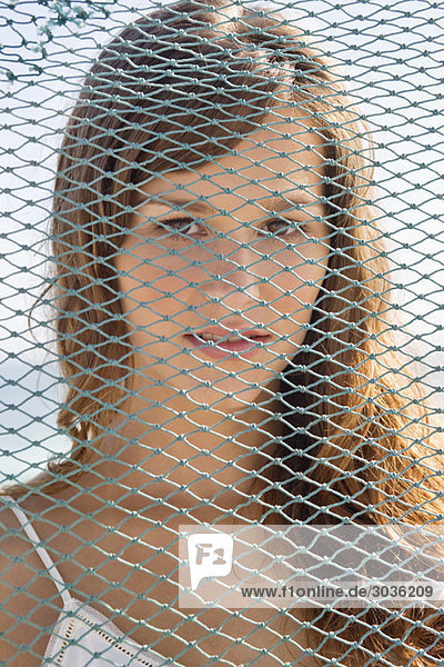 Portrait of a woman behind a net