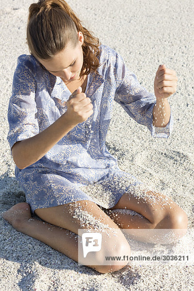 Woman playing with sand on the beach