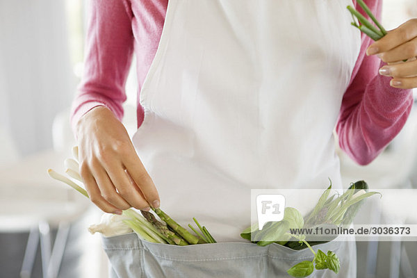 Frau stehend mit Gemüse in der Küche