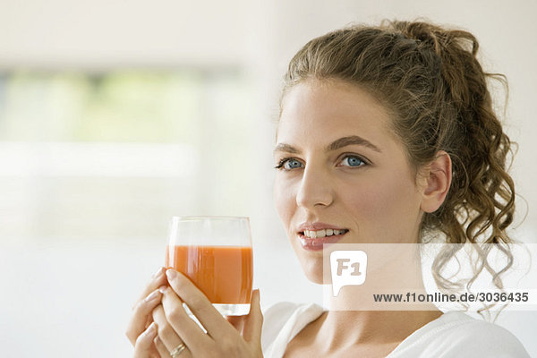 Frau mit einem Glas Tomatensuppe