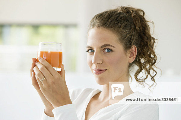 Portrait of a woman holding a glass of tomato soup