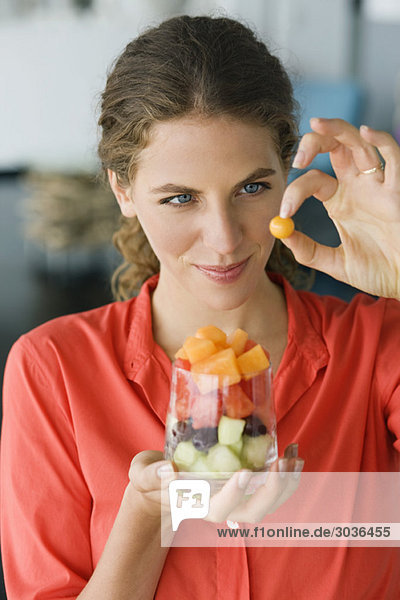 Close-up of a woman holding fruit salad