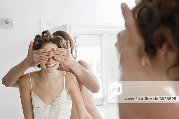 Man covering woman's eyes from behind