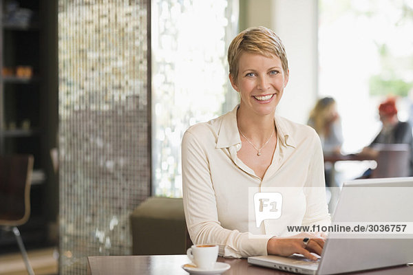 Geschäftsfrau bei der Arbeit am Laptop in einem Restaurant