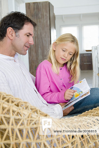 Mann und seine Tochter beim Lesen eines Buches