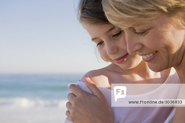 Frau mit ihrer Tochter im Urlaub am Strand