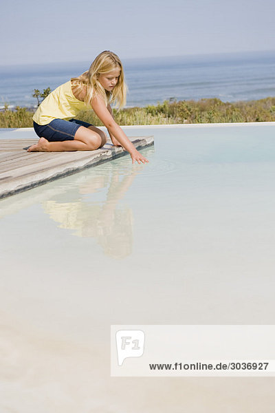 Girl playing on a platform at an infinity pool
