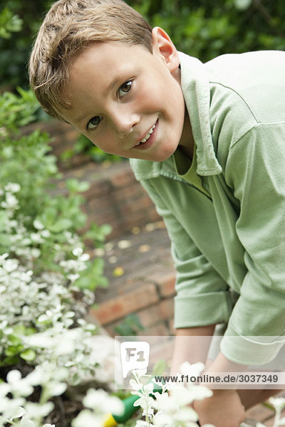 Porträt eines Jungen bei der Gartenarbeit