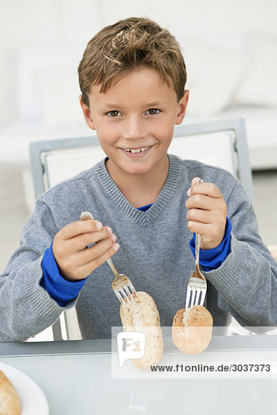 Junge stößt Gabeln auf Brot und lächelt