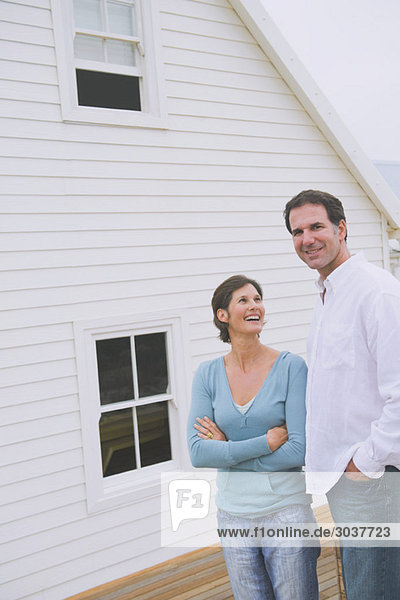 Couple standing together in front of a house