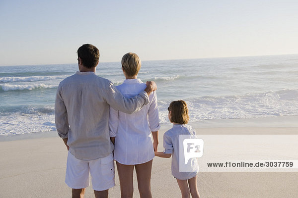 Family standing on the beach