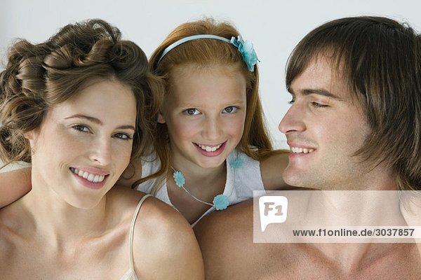 Close-up of a couple smiling with their daughter