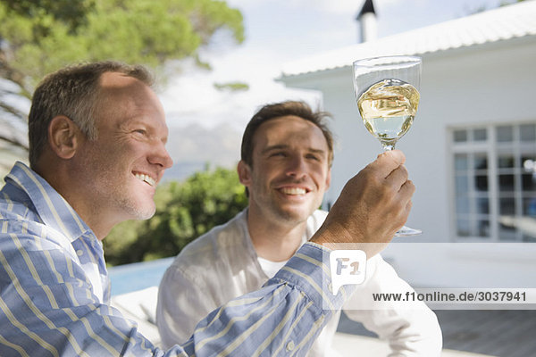 Zwei Freunde beim Betrachten eines Weinglases