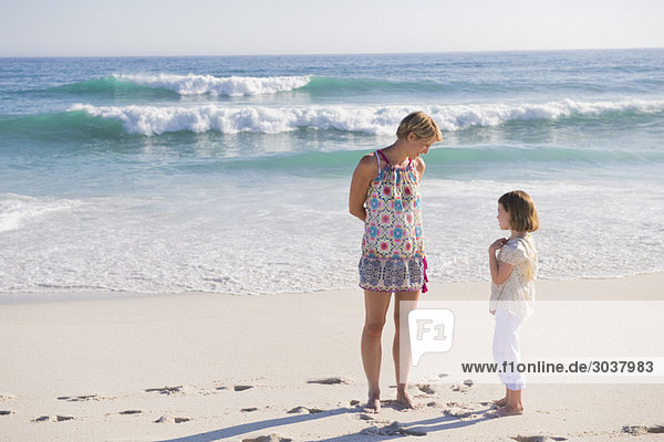 Woman standing on the beach with her daughter