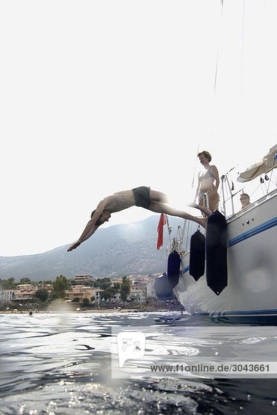 Man diving into water from sailing boat