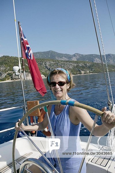 Woman sailing  taking the wheel