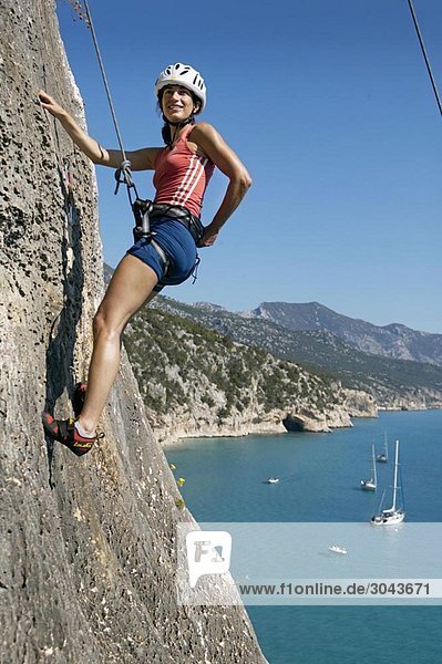 Woman rock climbing looking happy