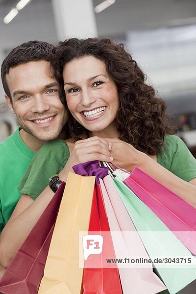 couple shopping holding up shopping bags