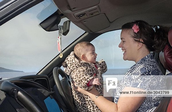 mother in car holding baby