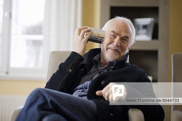 alter Mann spielt mit Dose Telefon