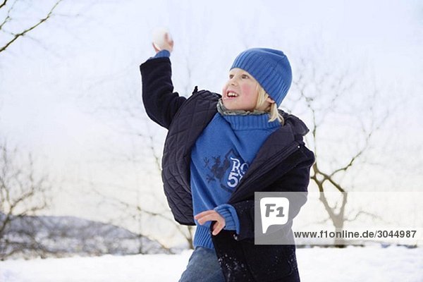 Scandinavian boy throwing snowball