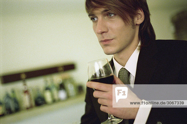 Junger Mann mit einem Glas Wein