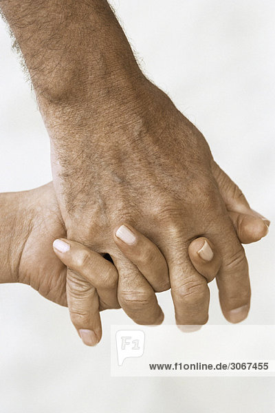 Man's hand holding woman's hand