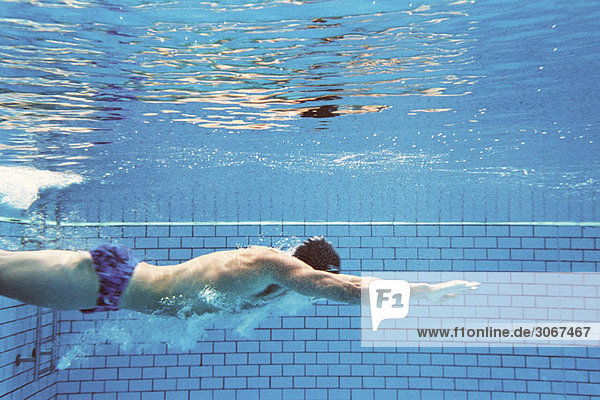 Mann schwimmt unter Wasser  Seitenansicht