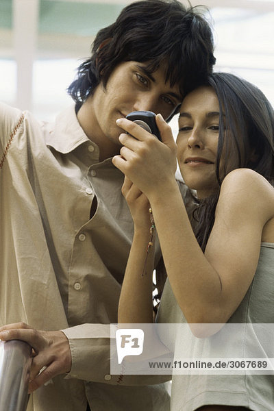 Junges Paar schaut zusammen aufs Handy
