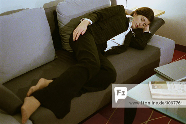 Geschäftsfrau voll bekleidet schlafend auf Sofa