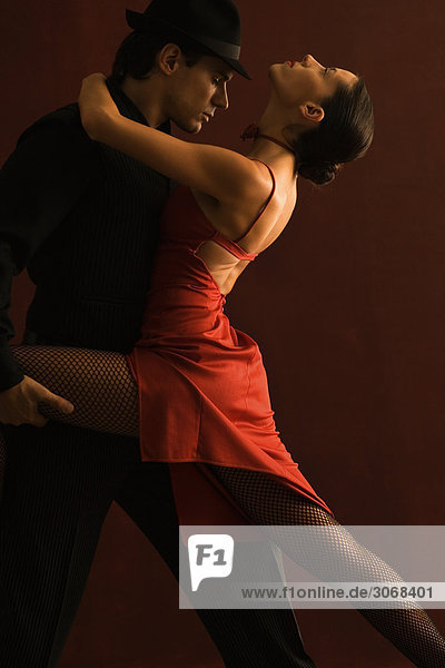Paar Tango tanzen zusammen  Mann hält Frauenbein  Frau lehnt sich zurück
