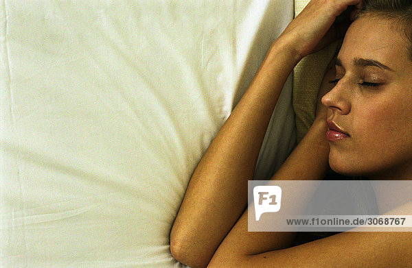 Frau im Bett liegend  Gesicht und Arme