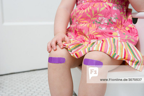 Girl with plasters on her knees