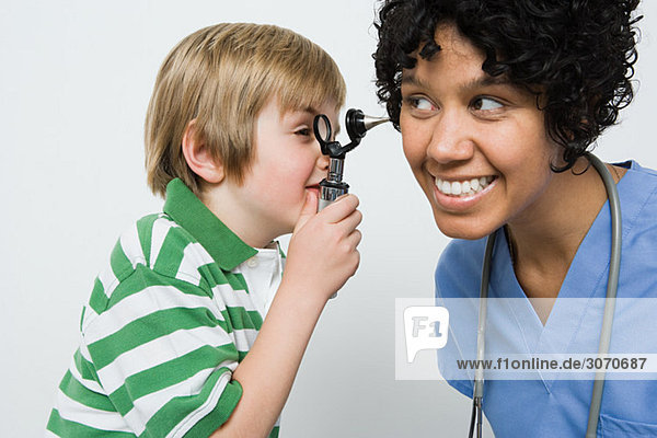 Boy looking in nurses ear