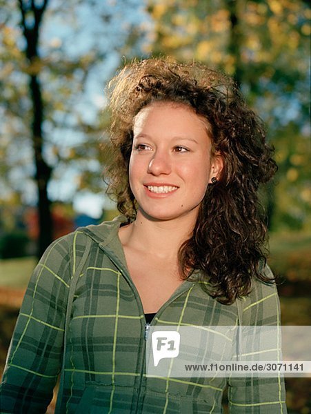 Portrait einer lächelnd Teenagerin in der herbstliche Sonne Schweden.