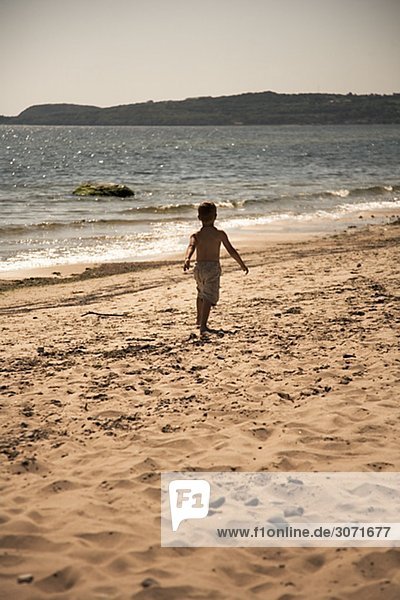 Ein Junge auf einem Strand Schweden zu Fuß.