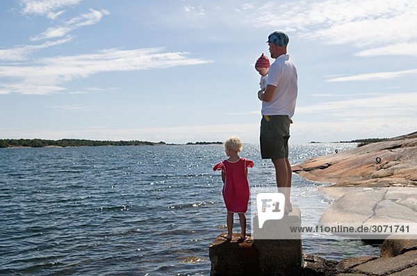 Vater mit Kindern am Meer Schweden.