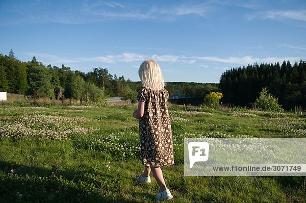 Ein Mädchen zu Fuß entfernt auf einem Feld Schweden.