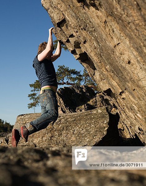 A man climbing a rock-face Sweden.