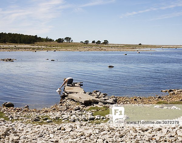 Eine Frau auf eine Mole Wasser Faro Gotland Schweden
